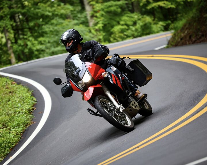 Alex Lang leaning a motorcycle through a mountain curve